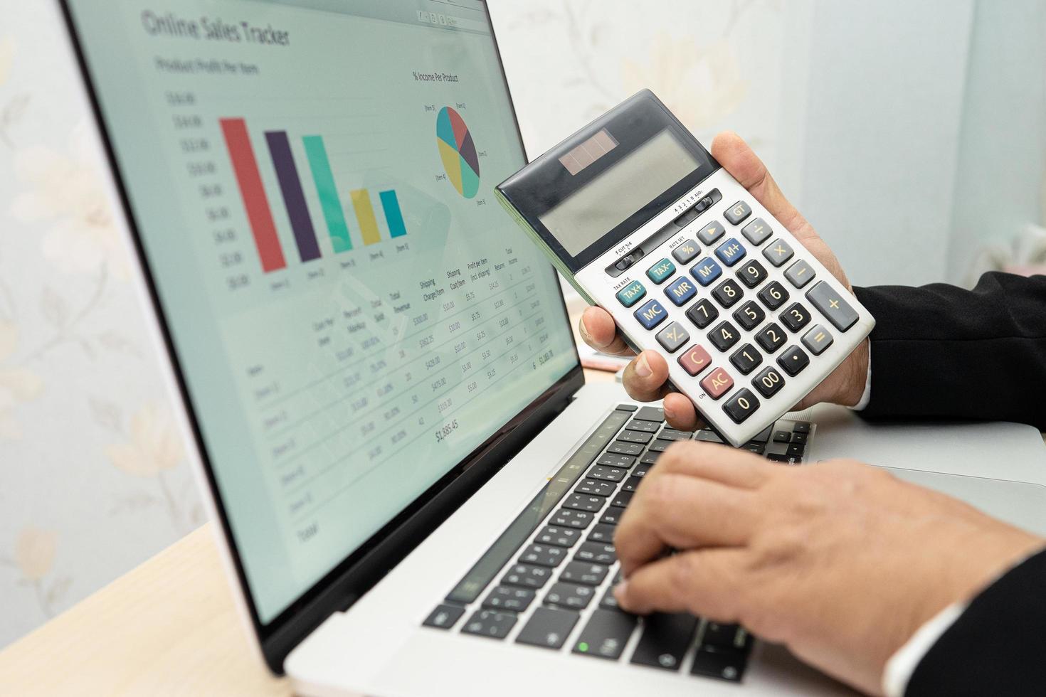 Asian accountant working and analyzing financial reports project accounting with chart graph and calculator in modern office, finance and business concept. photo