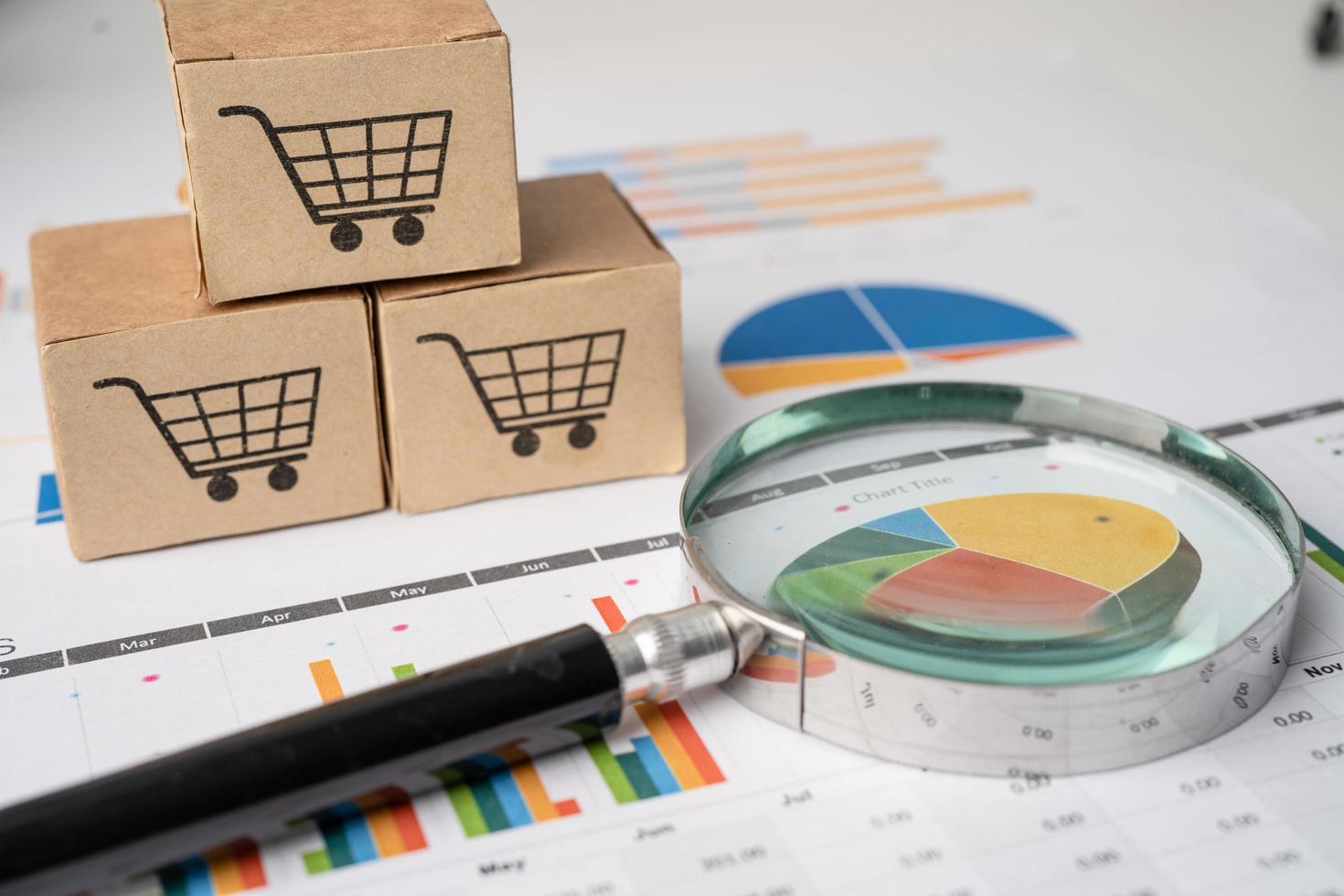 Shopping cart logo on box with magnifying glass on graph background. Banking Account, Investment Analytic research data economy, trading, Business import export transportation online company concept. photo