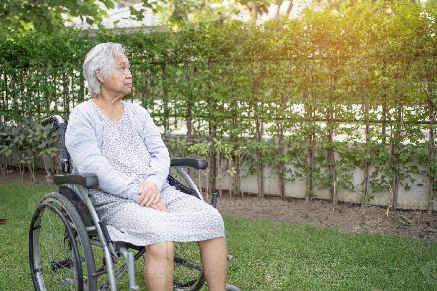 Paciente asiático mayor o mayor de la mujer de la señora mayor en silla de ruedas en el parque, concepto médico fuerte sano. foto