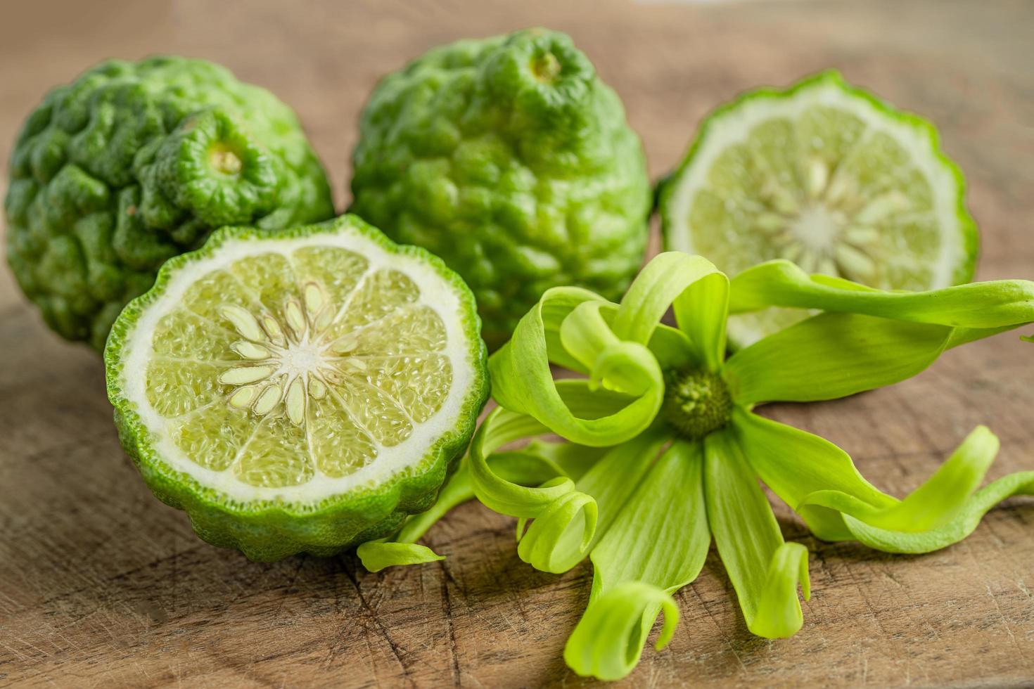 Fruta de bergamota fresca cortada por la mitad sobre fondo de madera. foto