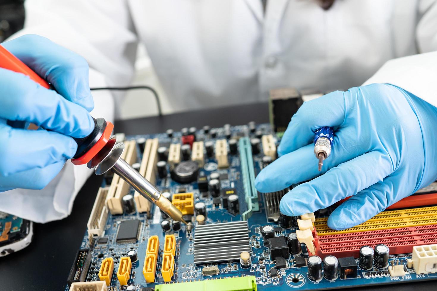 E-waste, technician repairing inside of hard disk by soldering iron. Integrated Circuit. the concept of data, hardware, technician and technology. photo