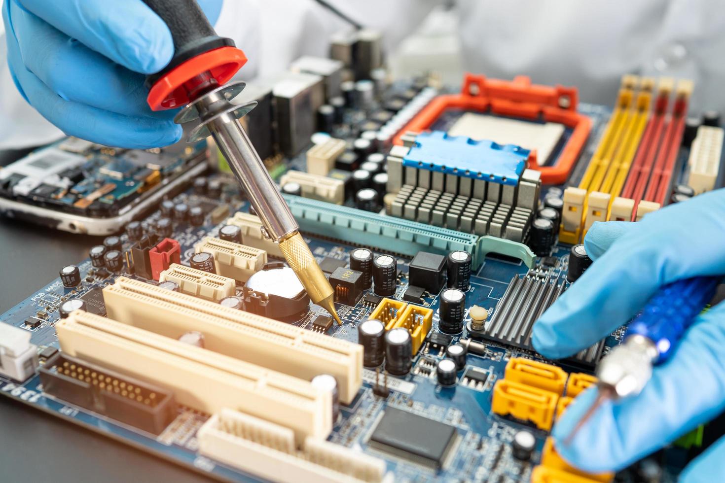 Technician repairing inside of hard disk by soldering iron. Integrated Circuit. the concept of data, hardware, technician and technology. photo