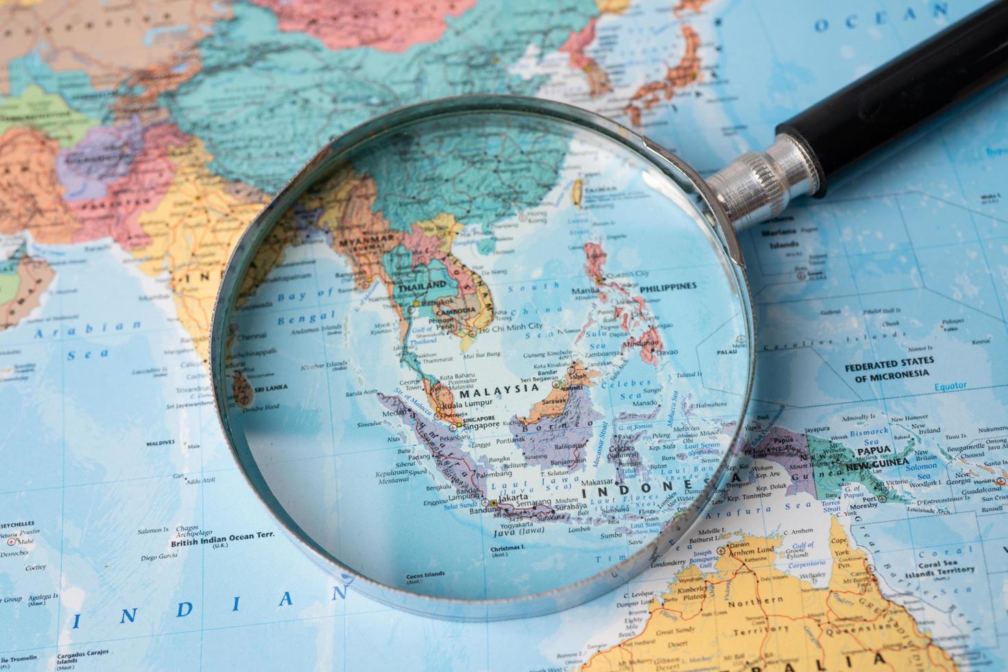 Bangkok, Thailand - August 01, 2020 Asia, Magnifying glass close up with colorful world map photo