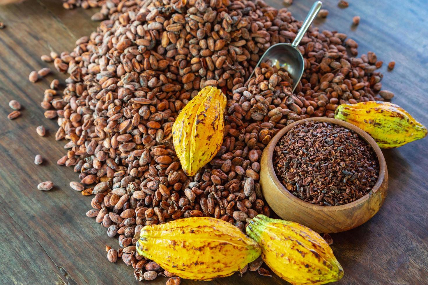 cocoa nibs and cocoa fruit on wooden table photo