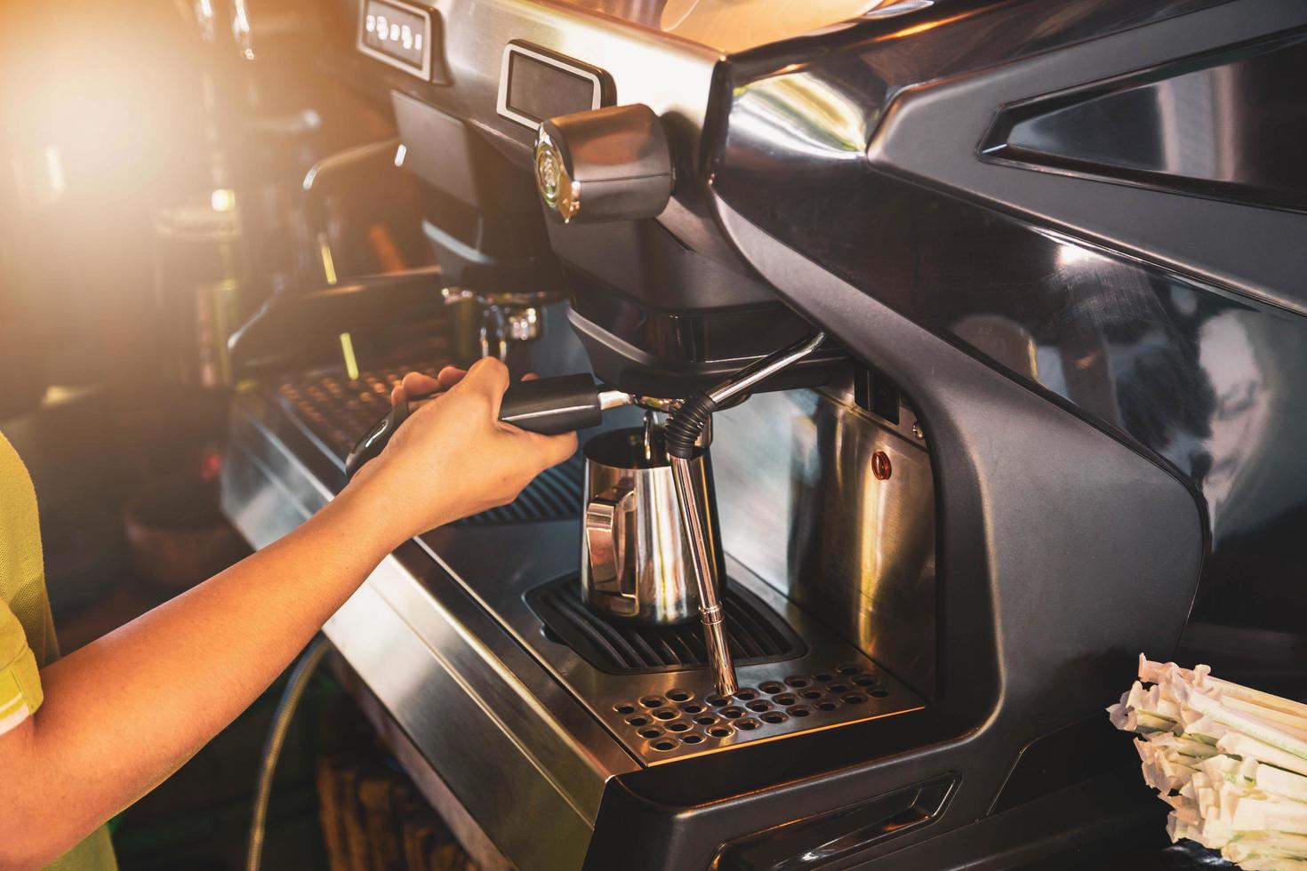 barista, mujer asiática preparando café con una máquina de café. para iniciar una pequeña empresa en el concepto de industria alimentaria. foto