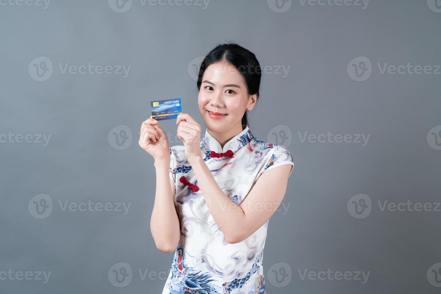 Asian woman wear Chinese traditional dress with hand holding credit card photo