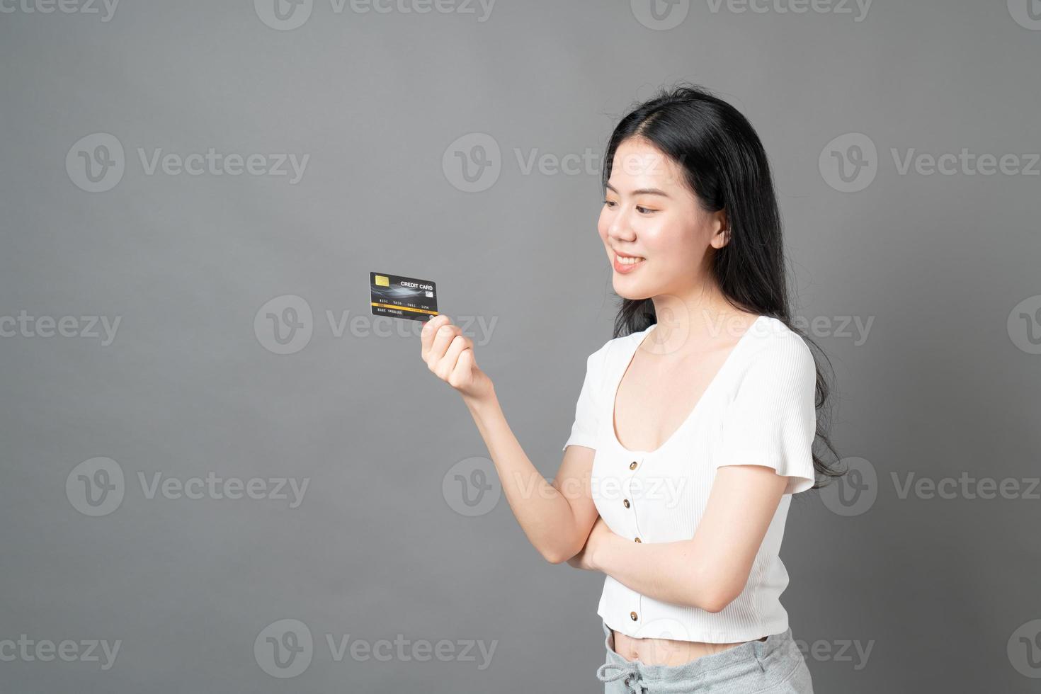 Asian woman with happy face and presenting credit card in hand showing trust and confidence for making payment photo