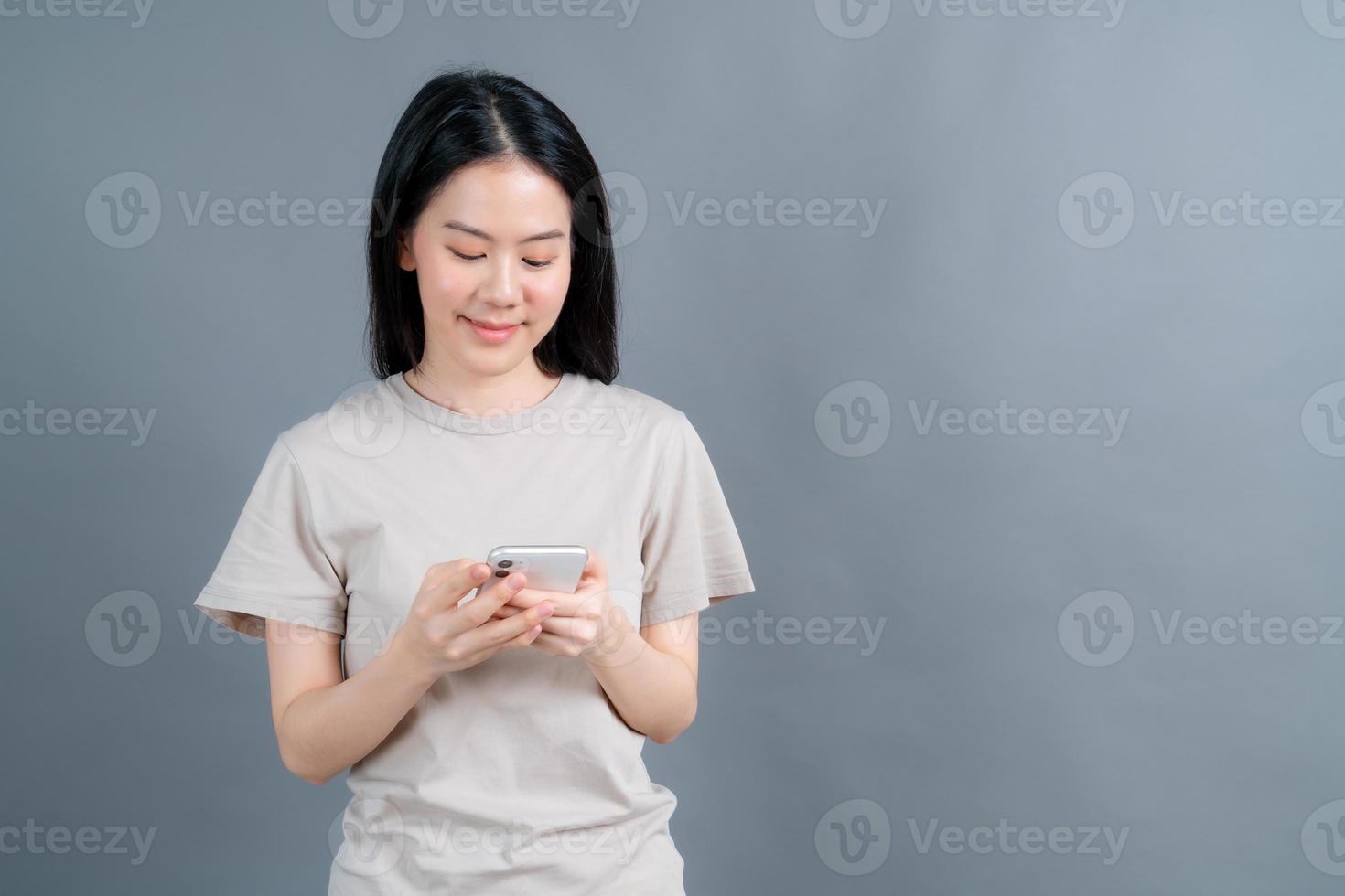 Mujer asiática que usa aplicaciones de teléfonos móviles, disfruta de la comunicación a distancia en línea en una red social o de compras. foto