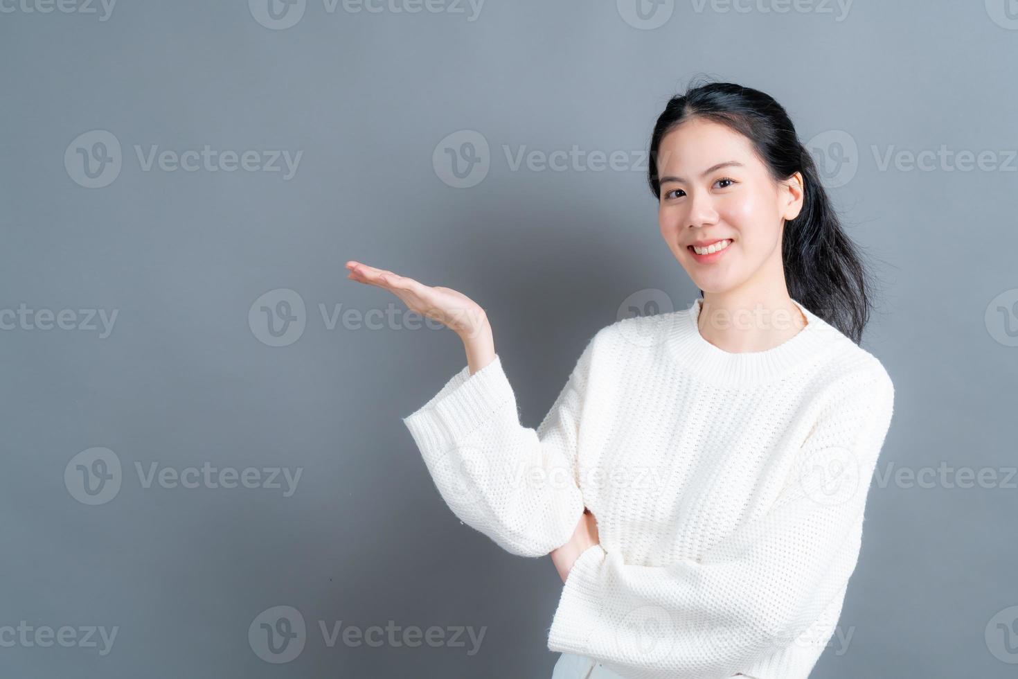 Asian woman with hand presenting on side photo