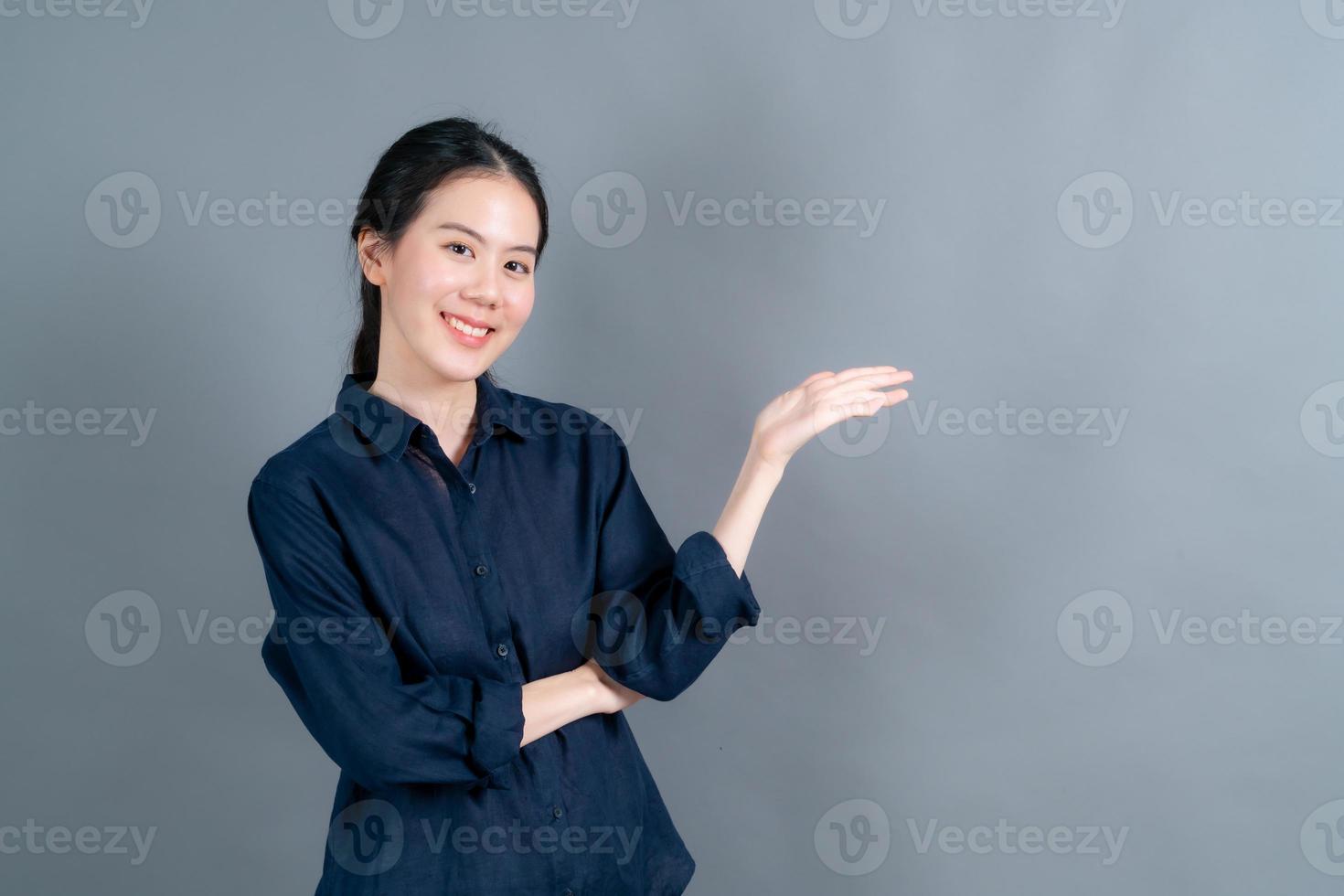 Asian woman with hand presenting on side photo