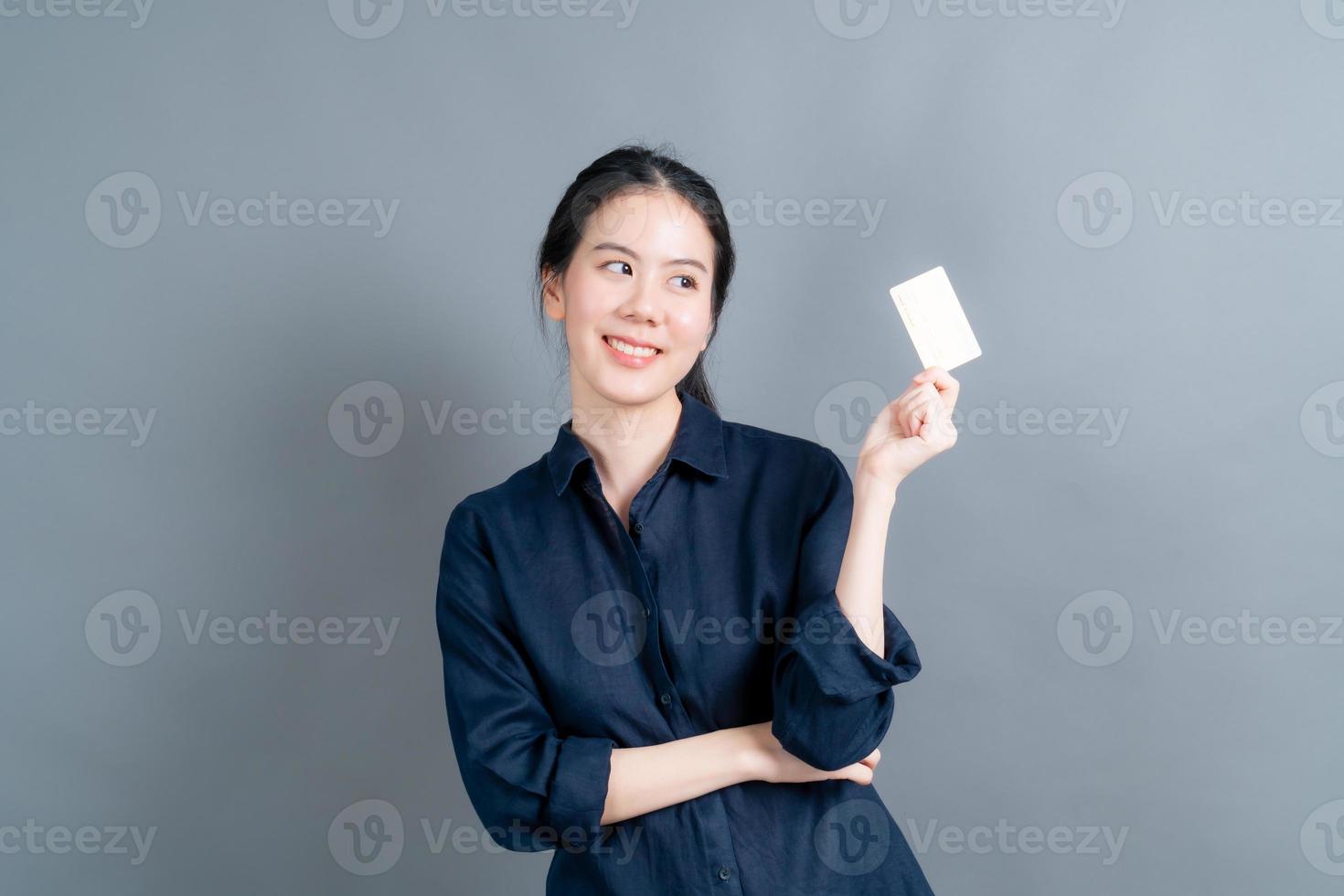 Portrait of a lovely young Asian woman showing credit card photo