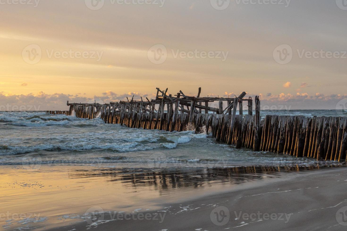 Hermosa playa de arena cerca del antiguo muelle rompeolas en uno de los balnearios más populares de Lituania foto