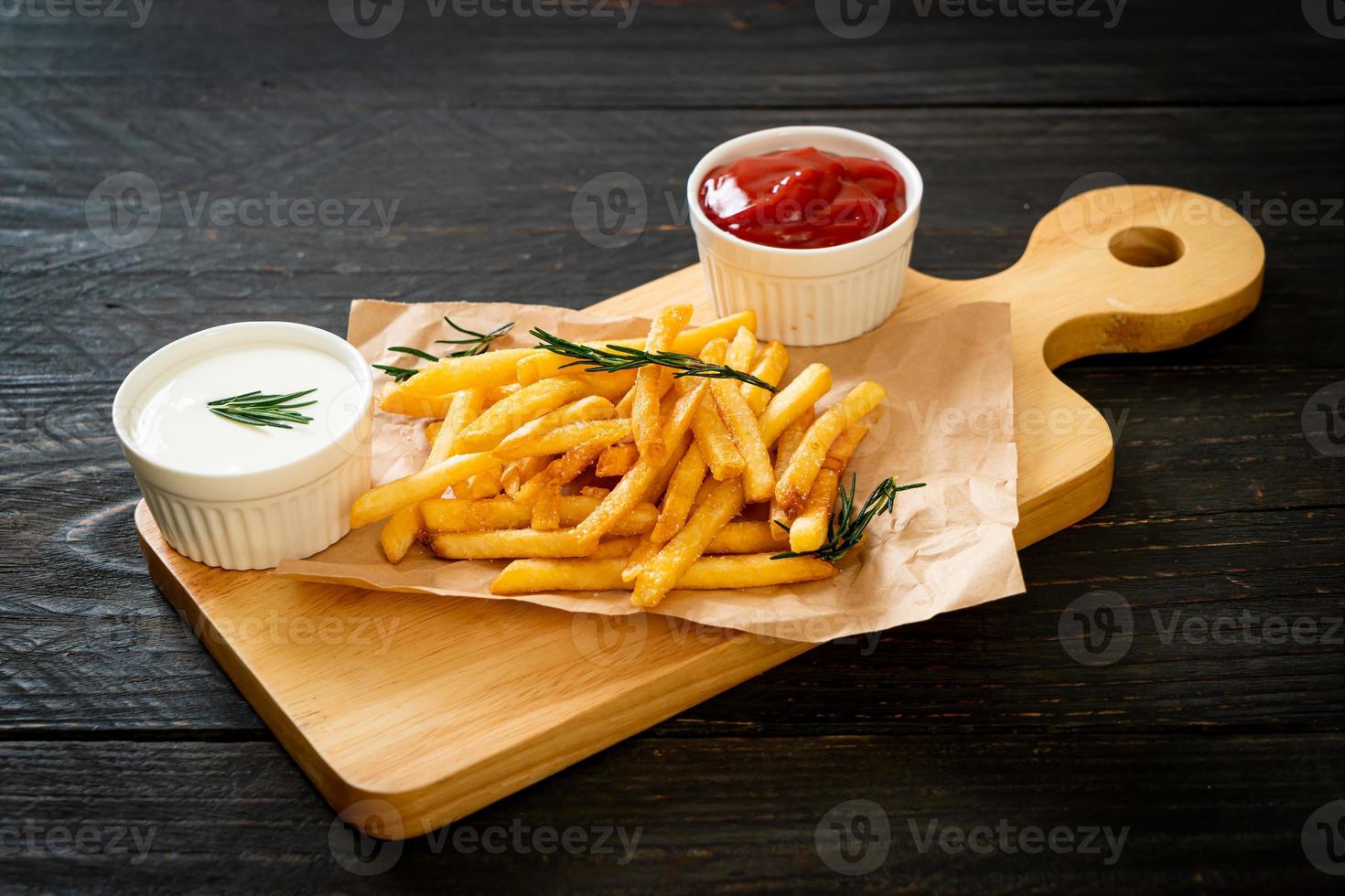 papas fritas con crema agria y salsa de tomate foto