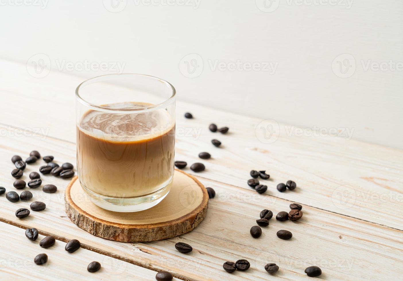 café sucio, leche fría cubierta con un chupito de café expreso caliente foto