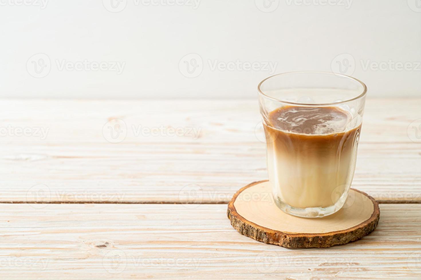 café sucio, leche fría cubierta con un chupito de café expreso caliente foto