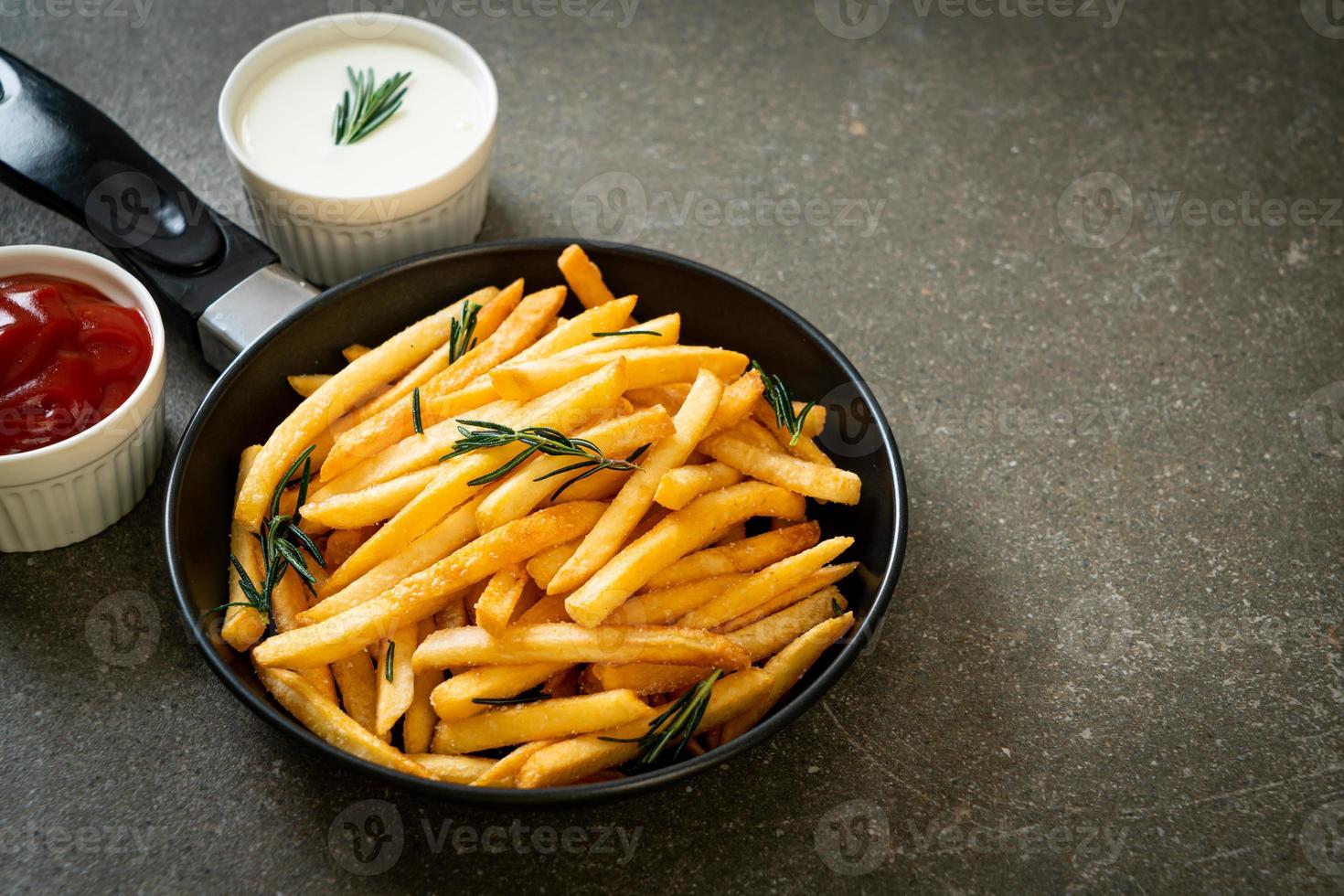 papas fritas con crema agria y salsa de tomate foto