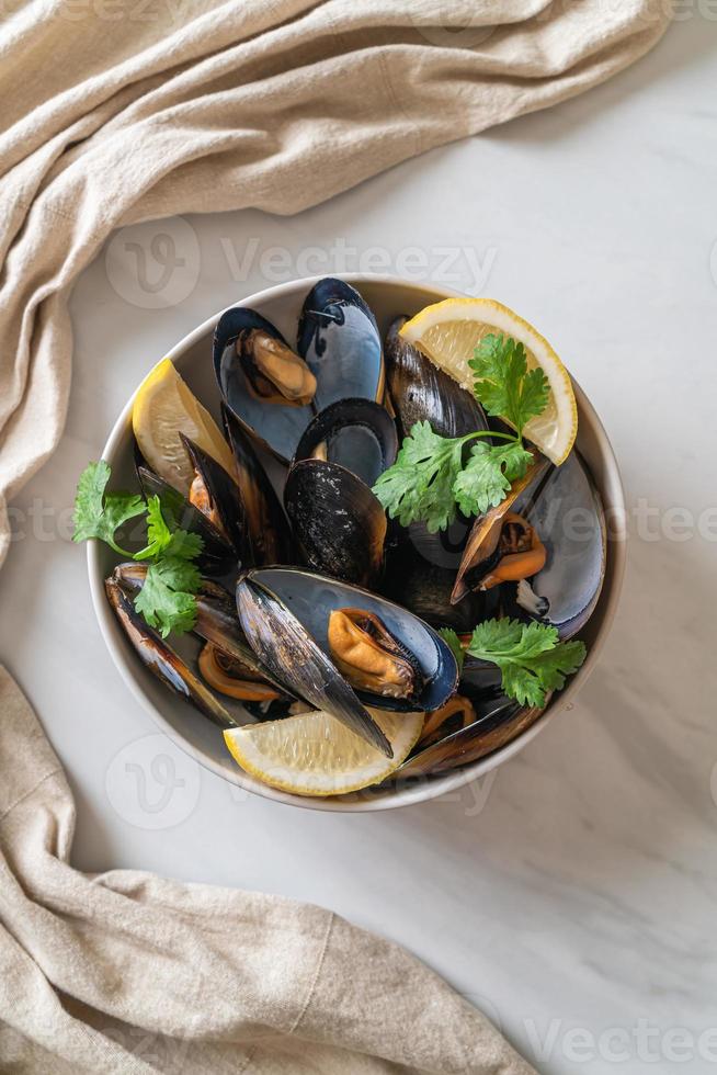 mejillones con hierbas en un bol con limón foto