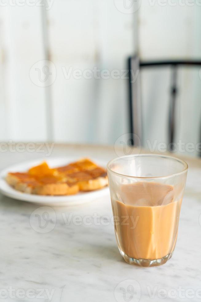 Vaso de té con leche tailandesa caliente en la mesa foto