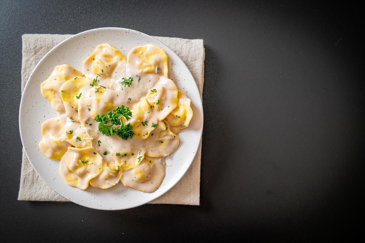 Ravioli pasta with mushroom cream sauce and cheese - Italian food style photo