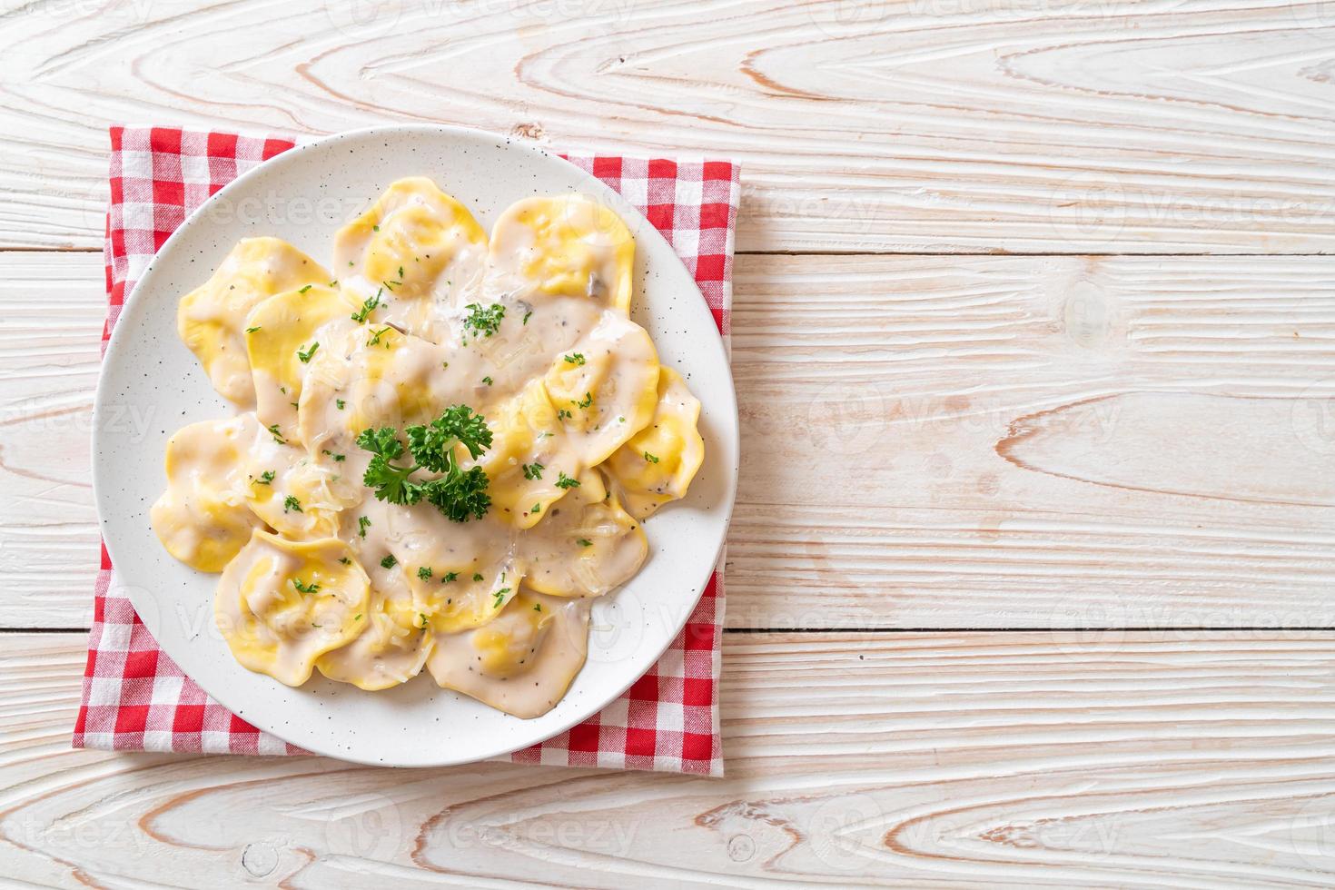 Ravioli pasta with mushroom cream sauce and cheese - Italian food style photo