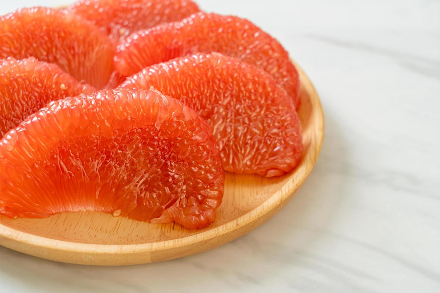 Fresh red pomelo fruit or grapefruit on plate photo