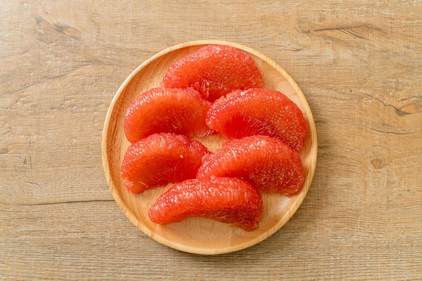 Fresh red pomelo fruit or grapefruit on plate photo