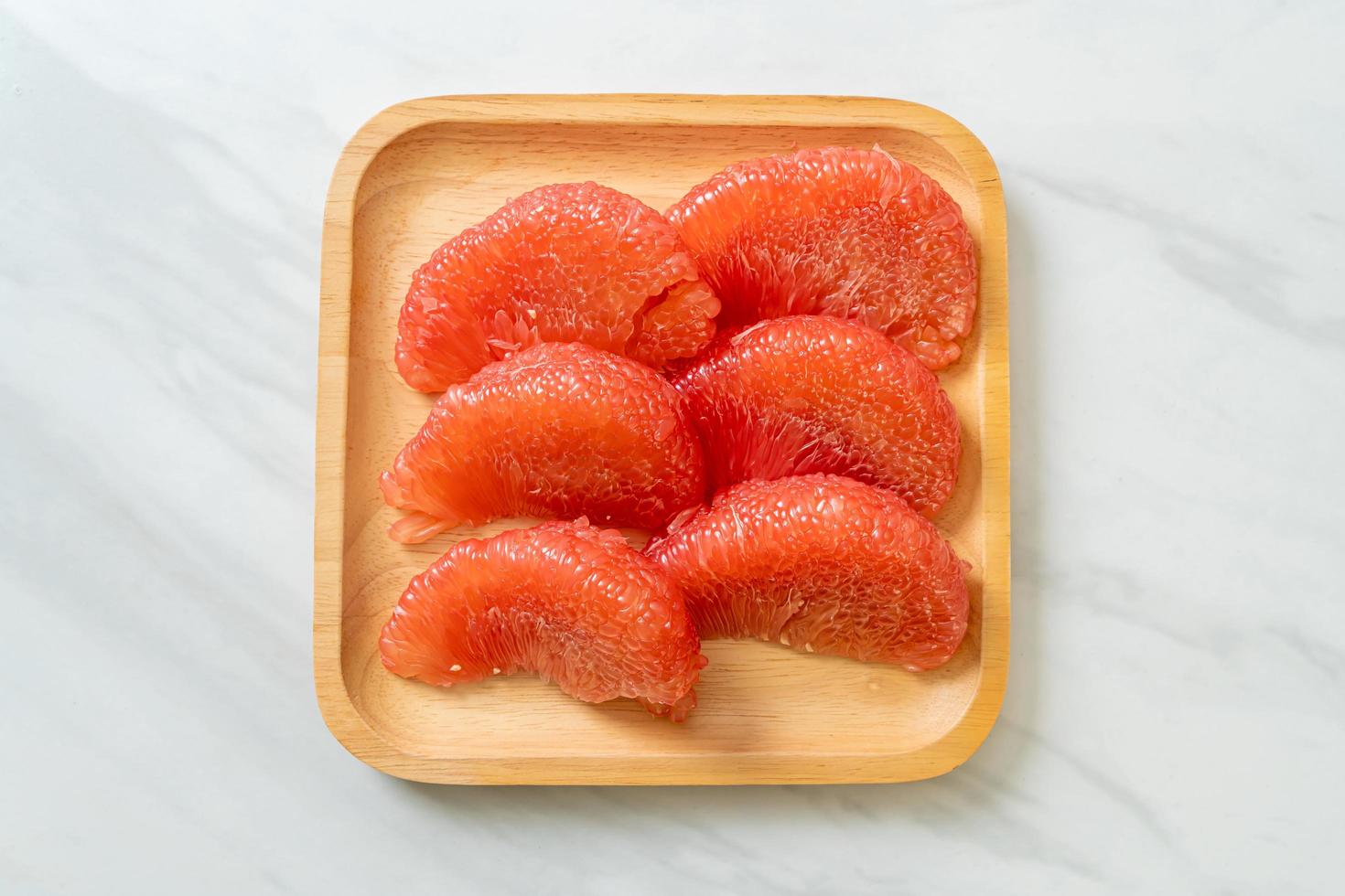 Fresh red pomelo fruit or grapefruit on plate photo