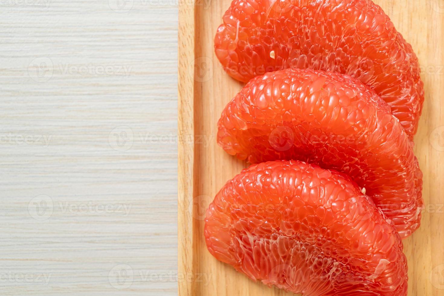 Fresh red pomelo fruit or grapefruit on plate photo