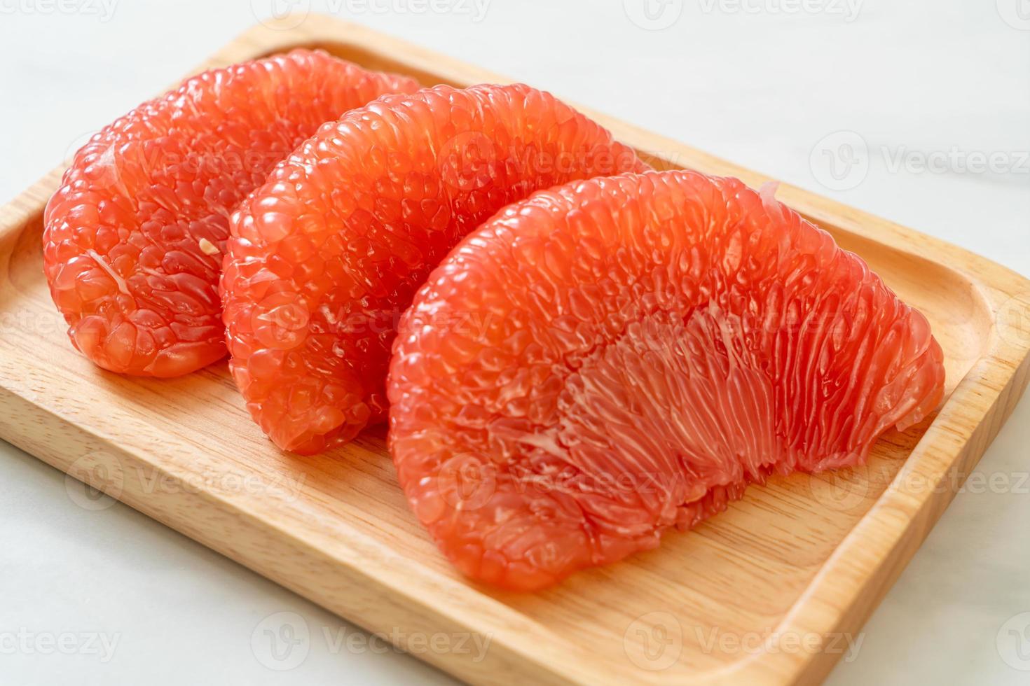 Fresh red pomelo fruit or grapefruit on plate photo