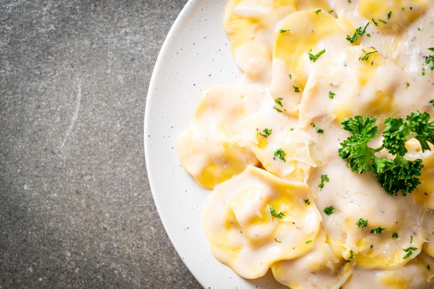 Ravioli pasta with mushroom cream sauce and cheese - Italian food style photo