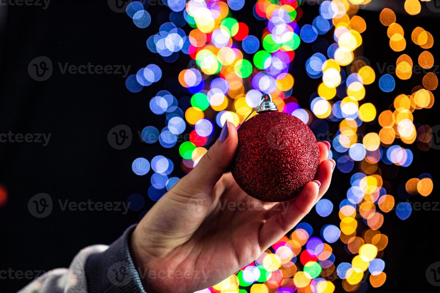 mano que sostiene la chuchería de navidad foto