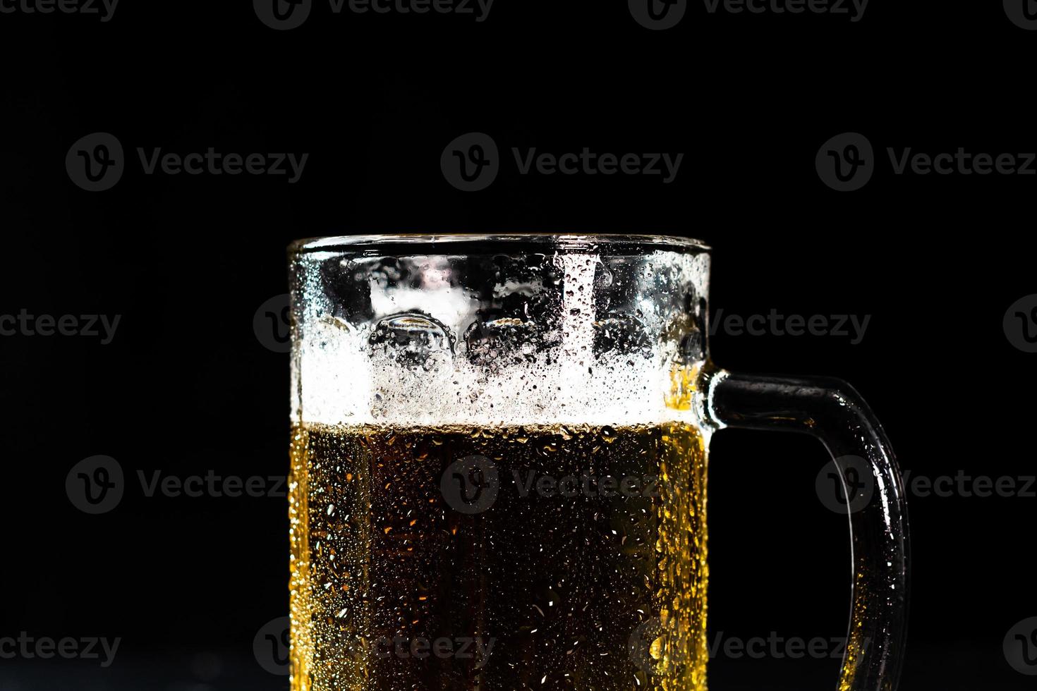 Glass of beer with beer foam on dark background photo