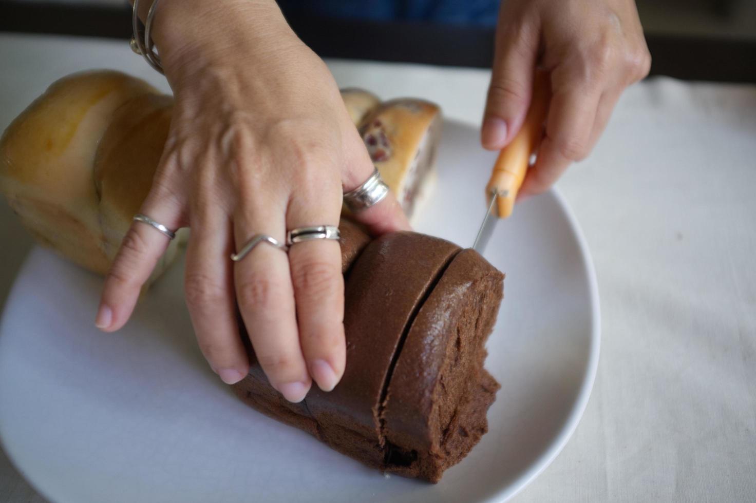 mujer sosteniendo un cuchillo de oro para cortar pan fresco. foto