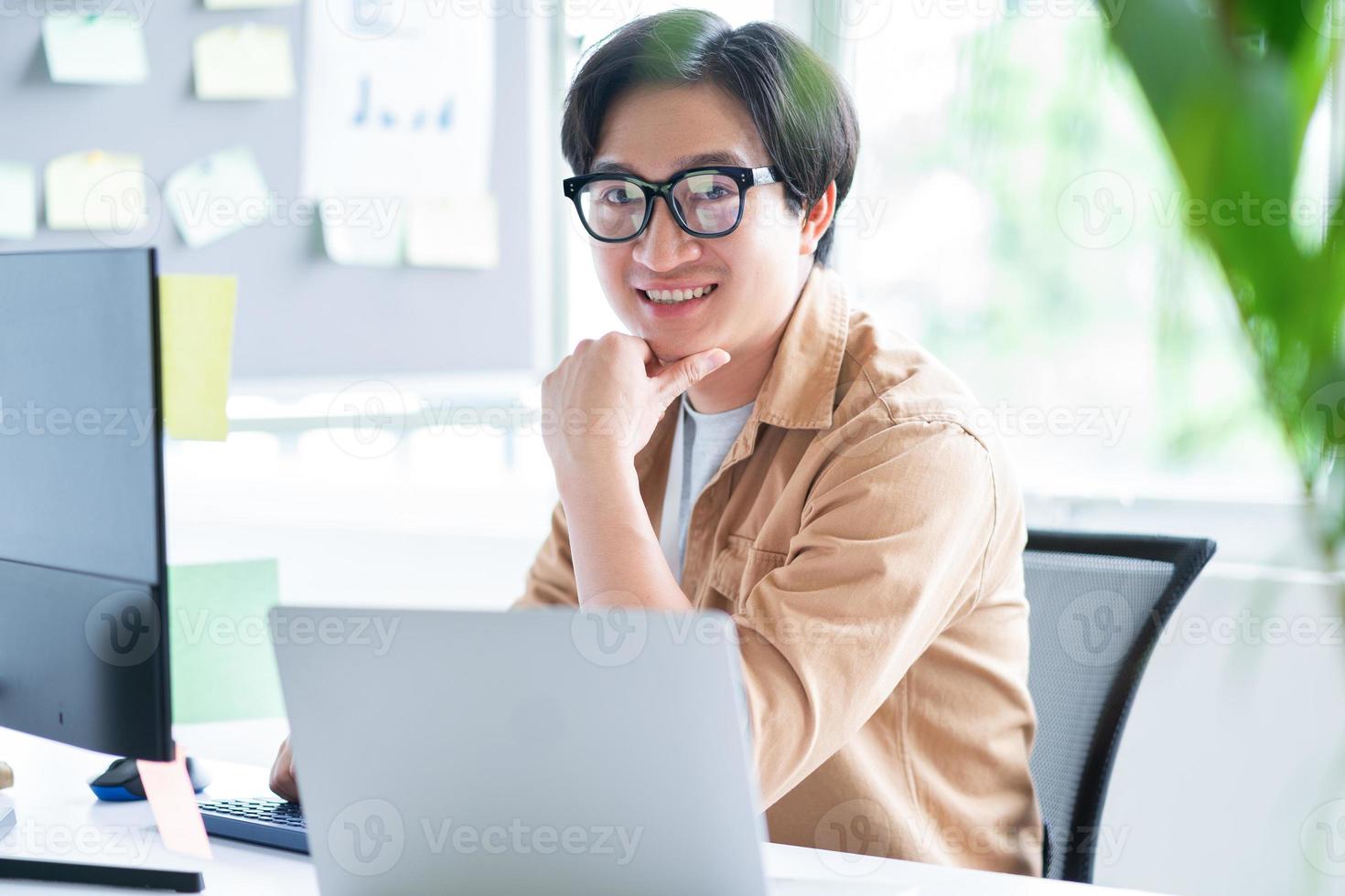 Hombre de negocios asiático que trabaja con la computadora en la oficina foto