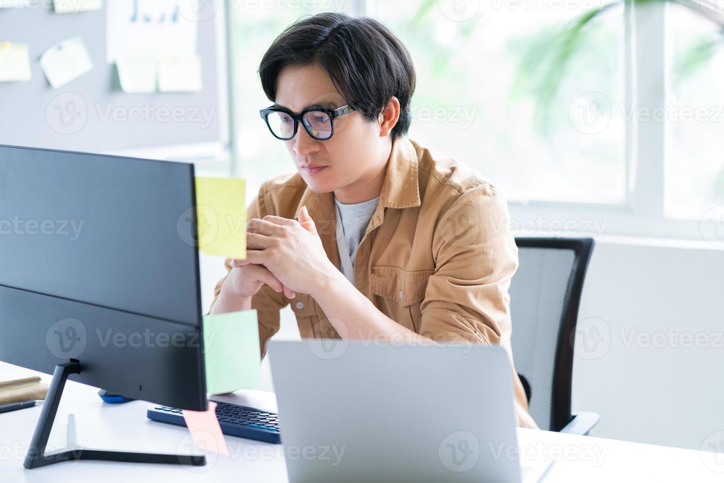 Hombre de negocios asiático que trabaja con la computadora en la oficina foto