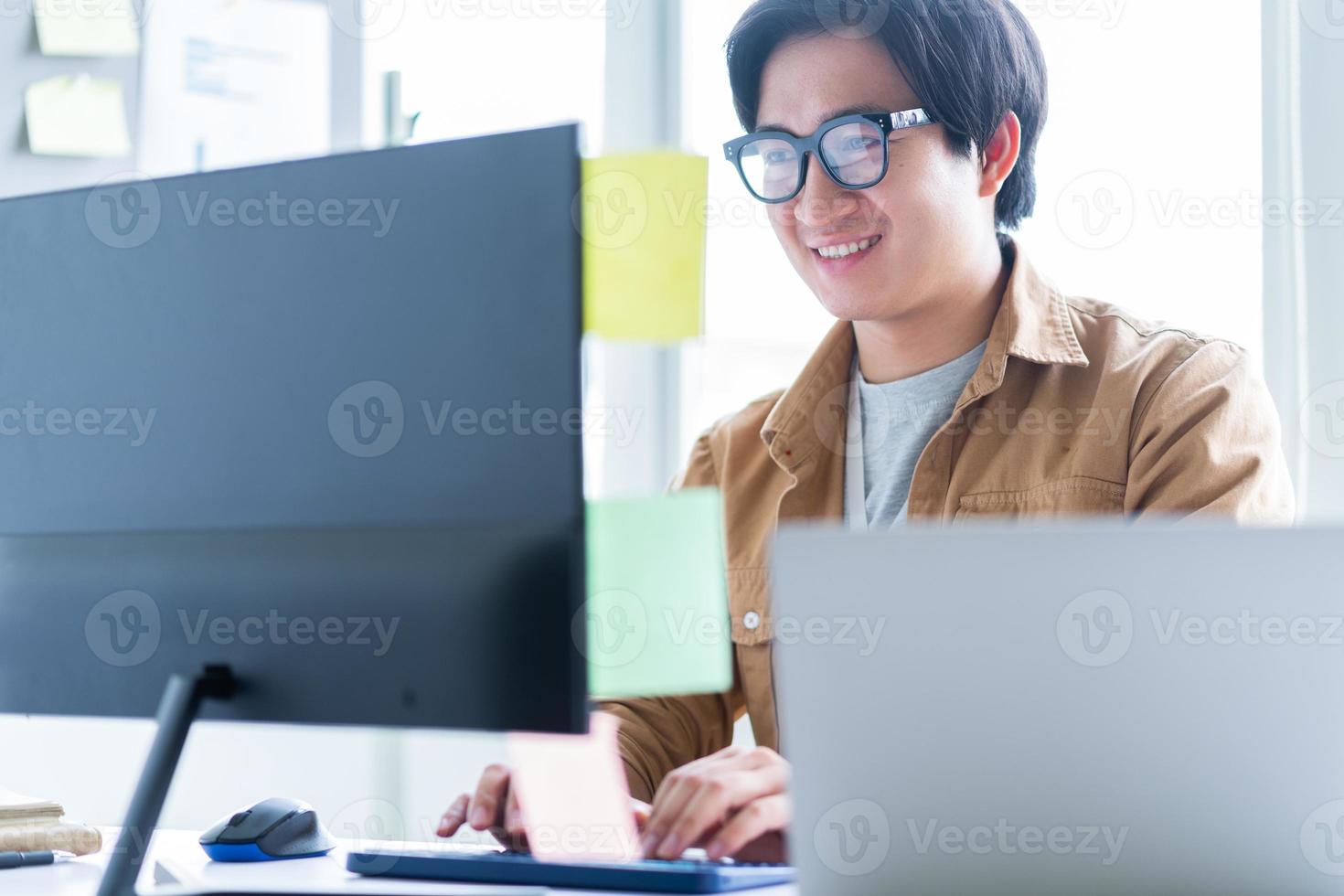 Hombre de negocios asiático que trabaja con la computadora en la oficina foto