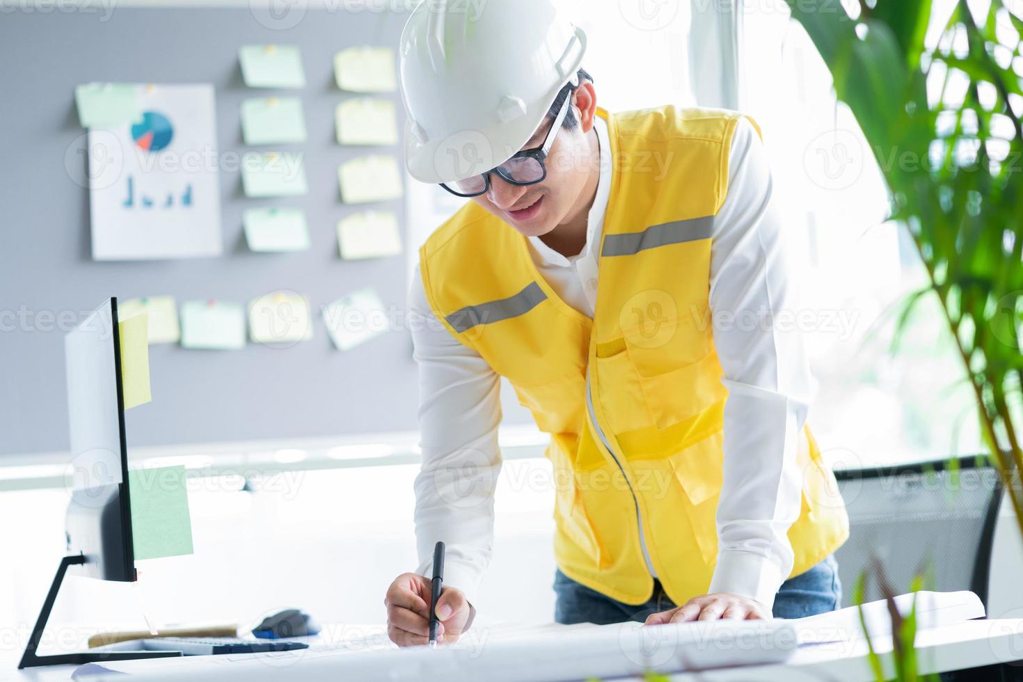 ingenieros asiáticos están haciendo dibujos de construcción foto