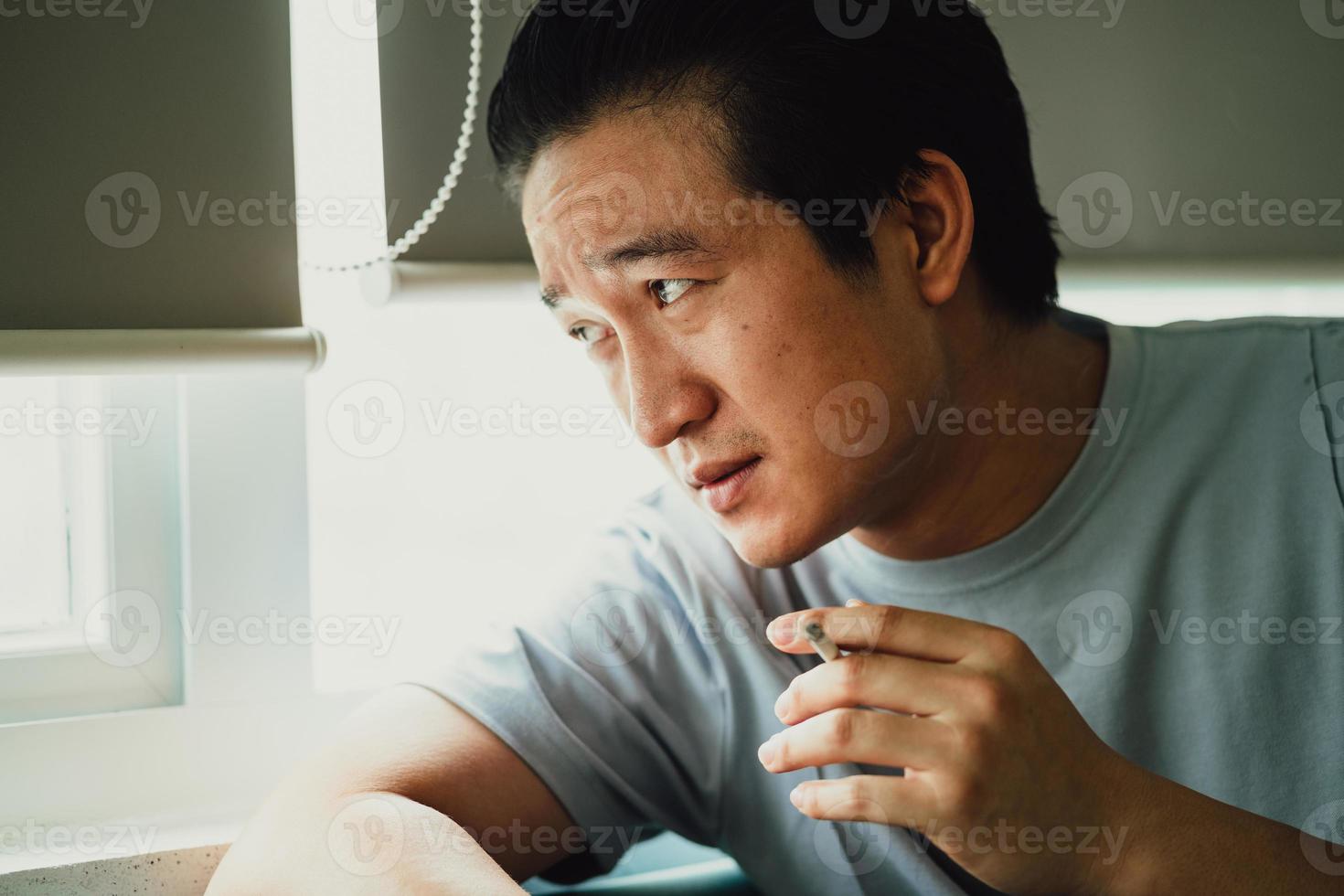 Asian man feels desperate for smoking addiction photo
