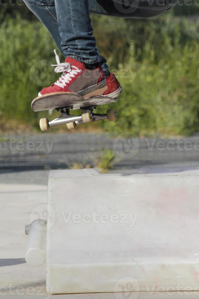 Jumping over an obstacle with the skateboard photo