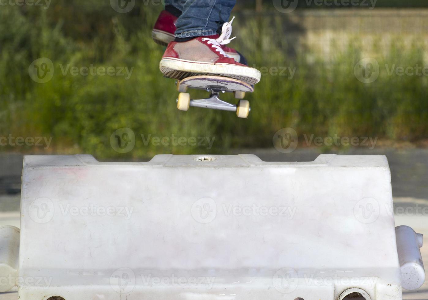 Jumping over an obstacle with the skateboard photo