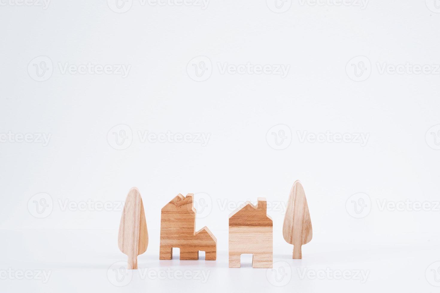 casas en miniatura y árboles sobre fondo blanco. modelo de casa de madera. foto