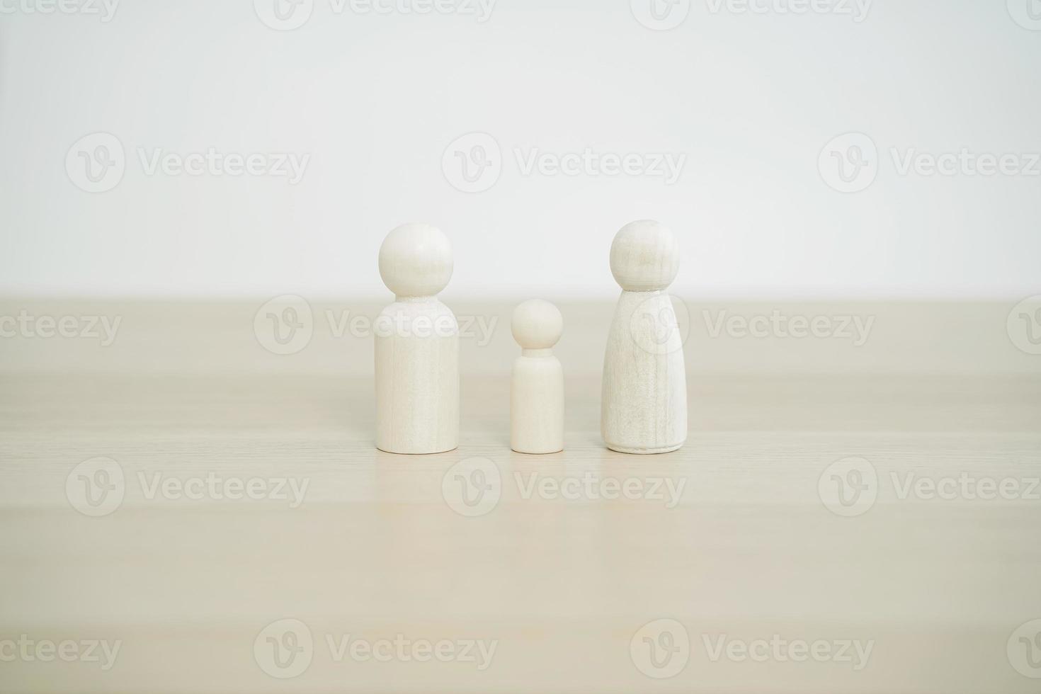 Family wooden peg doll on wood table. Family concept from peg doll. Selective focus. photo