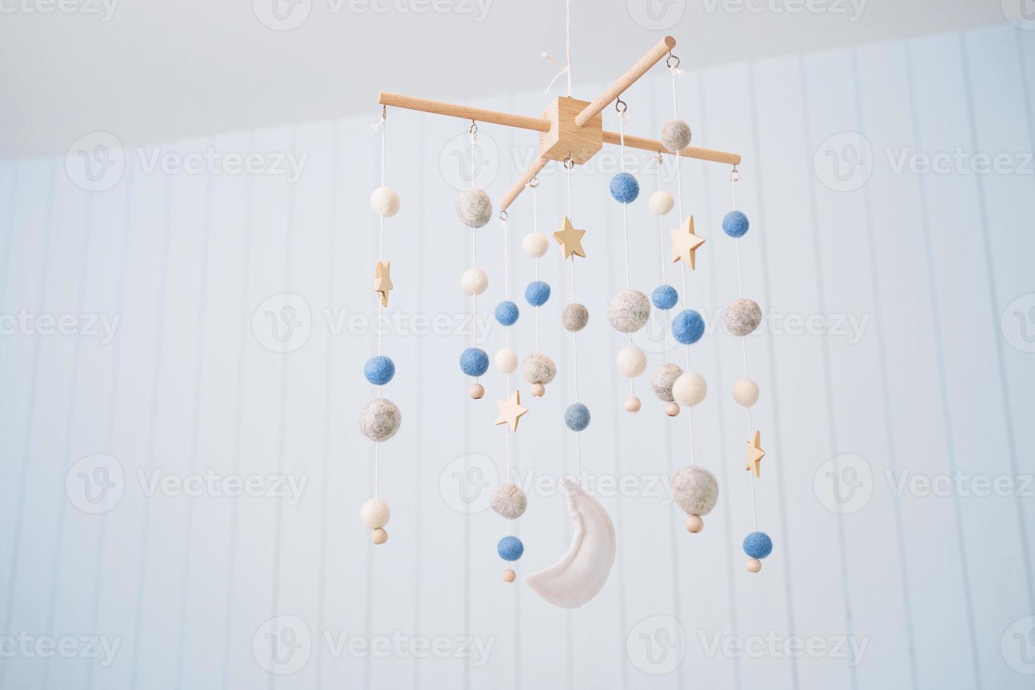 Baby crib mobile. Toys above the baby crib. Hanging soft balls for the child. photo