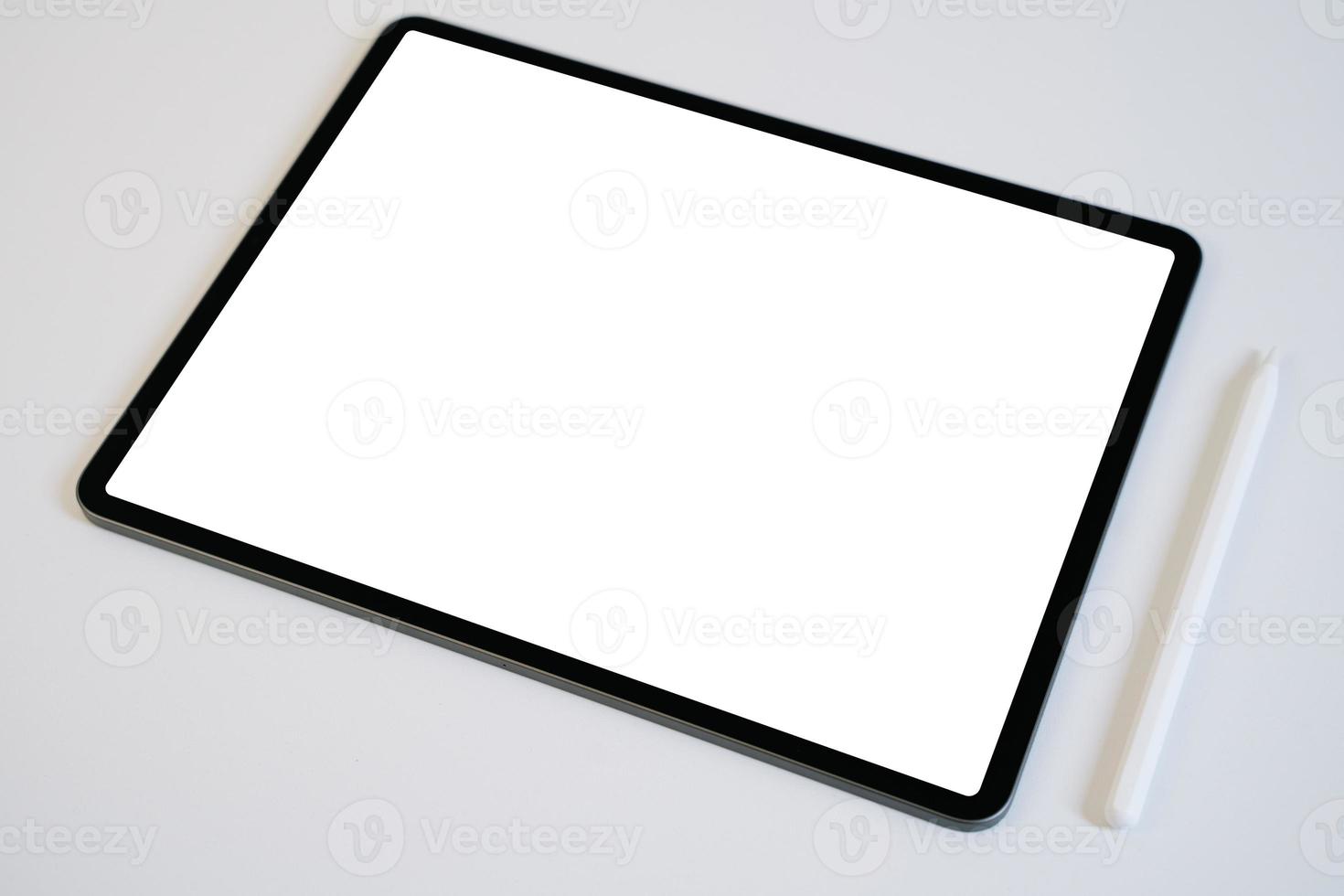 maqueta de tableta y lápiz digital con pantalla en blanco en blanco sobre mesa blanca. foto