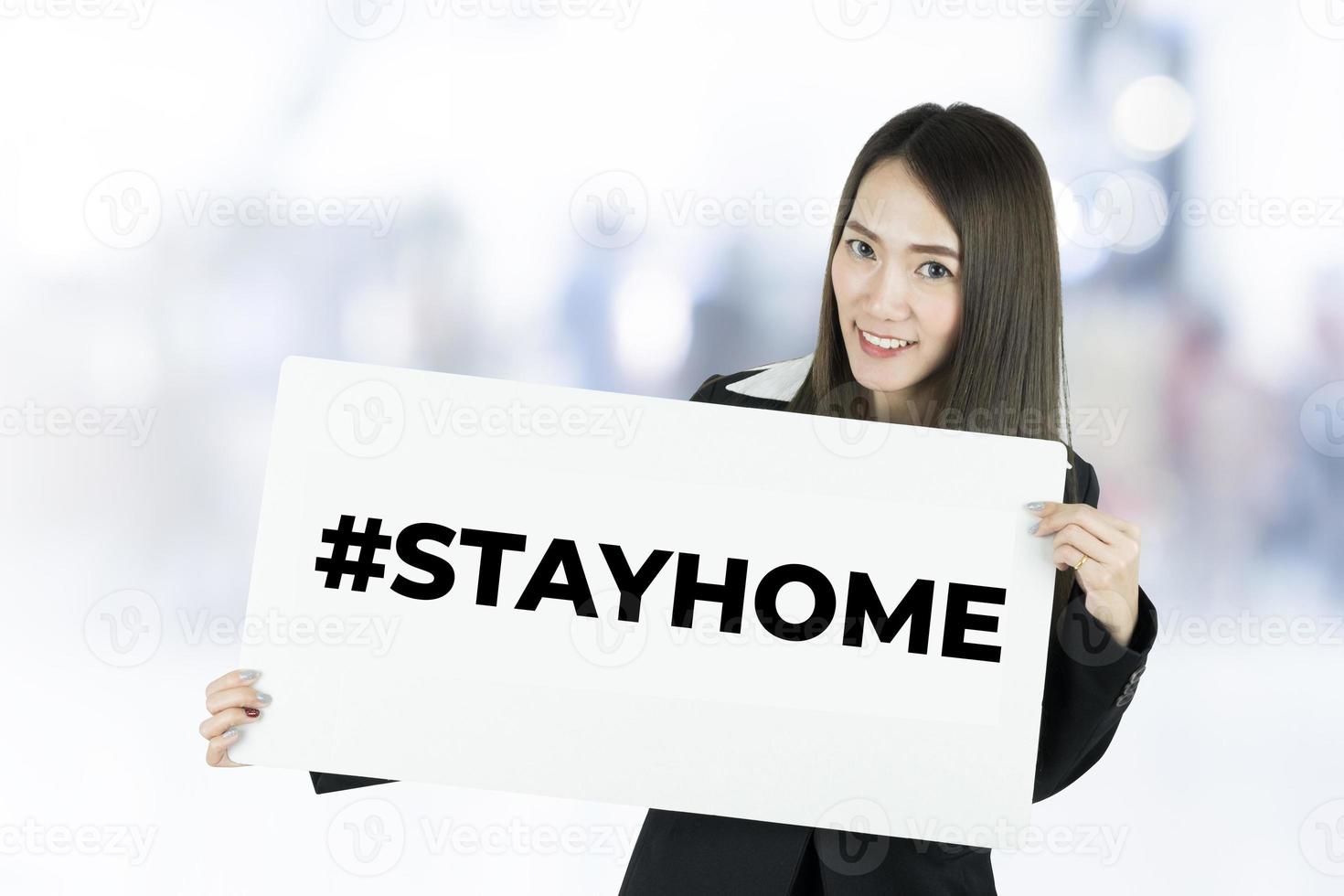 Businesswoman with white paper sheet with hashtag stay home. Call to stay home during a coronavirus epidemic to protect against the virus. photo