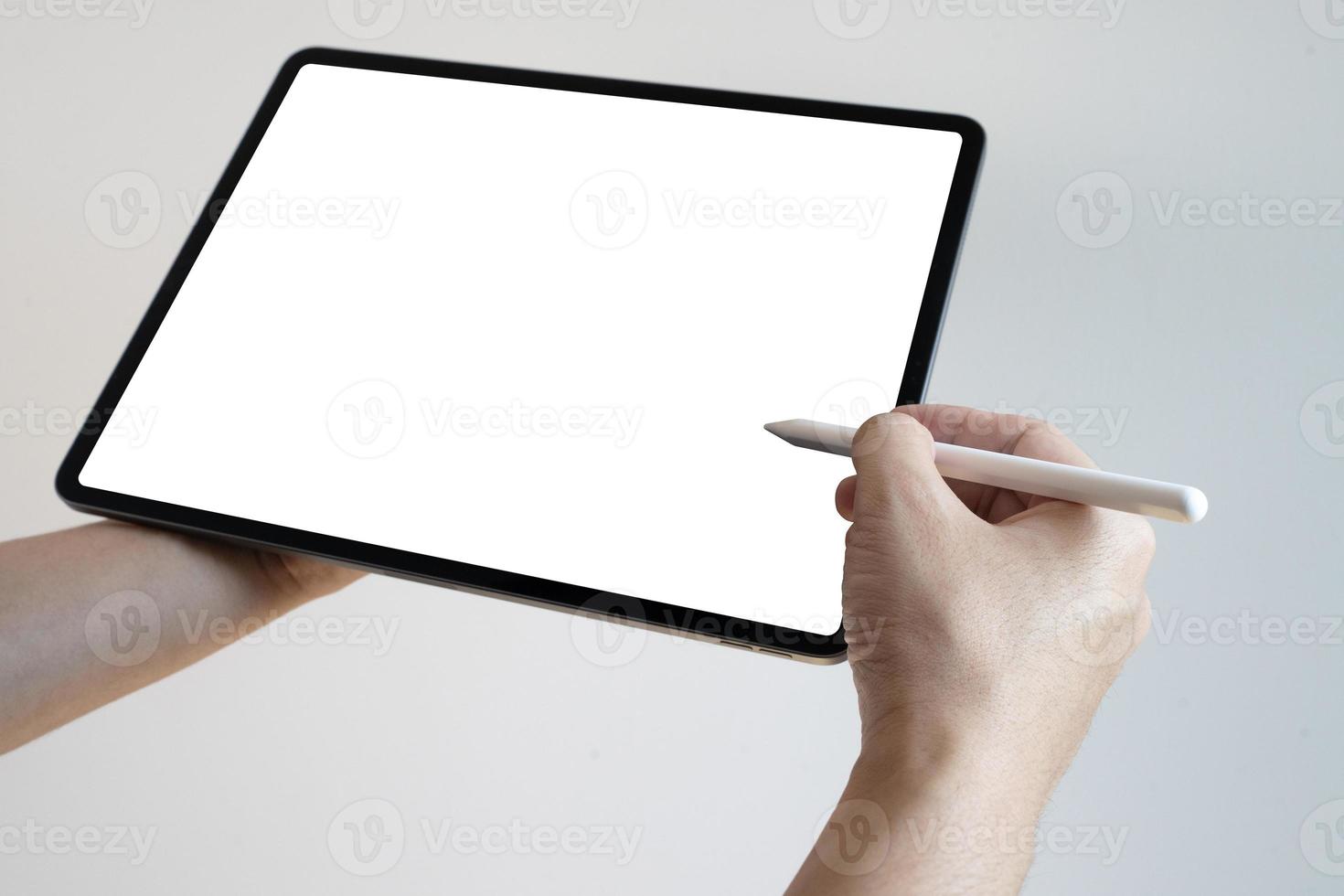 Hand using digital tablet pen touch blank screen. Hands holding and writing on digital tablet. photo