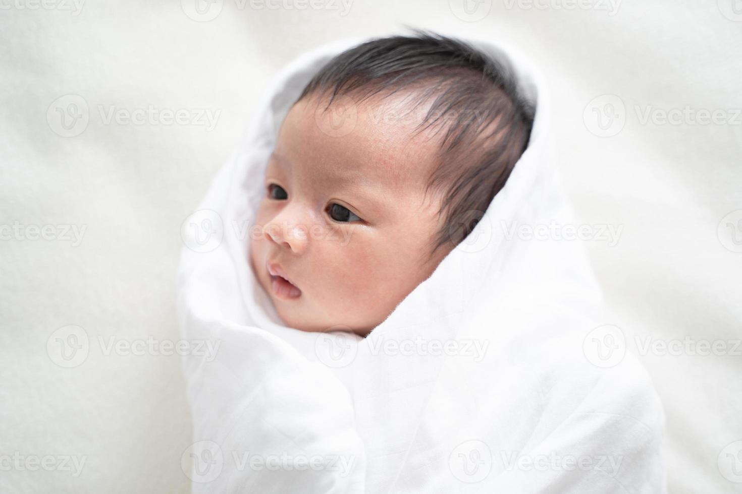 Newborn baby in white blanket. photo