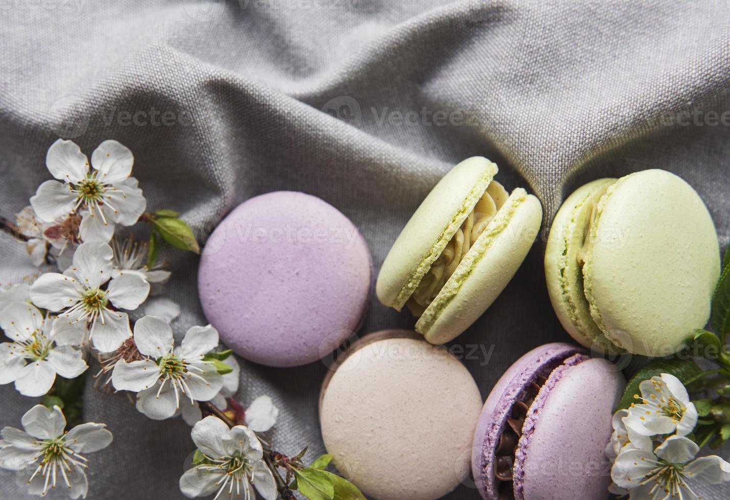 Macarrones dulces franceses variedad colorida sobre un fondo gris textil foto