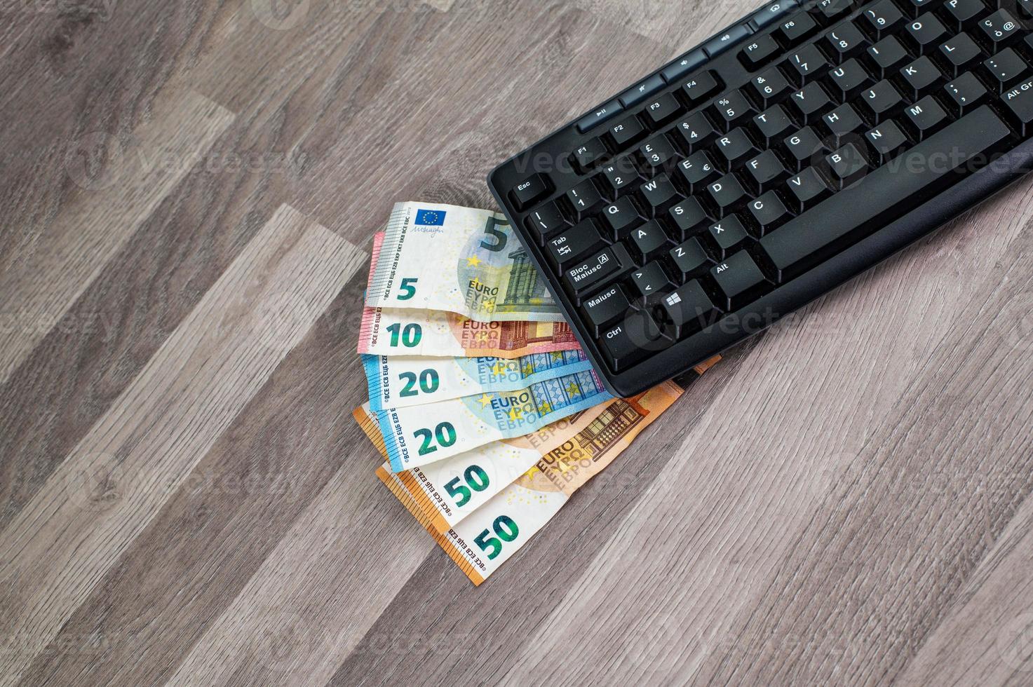 Teclado de computadora con billetes en euros foto