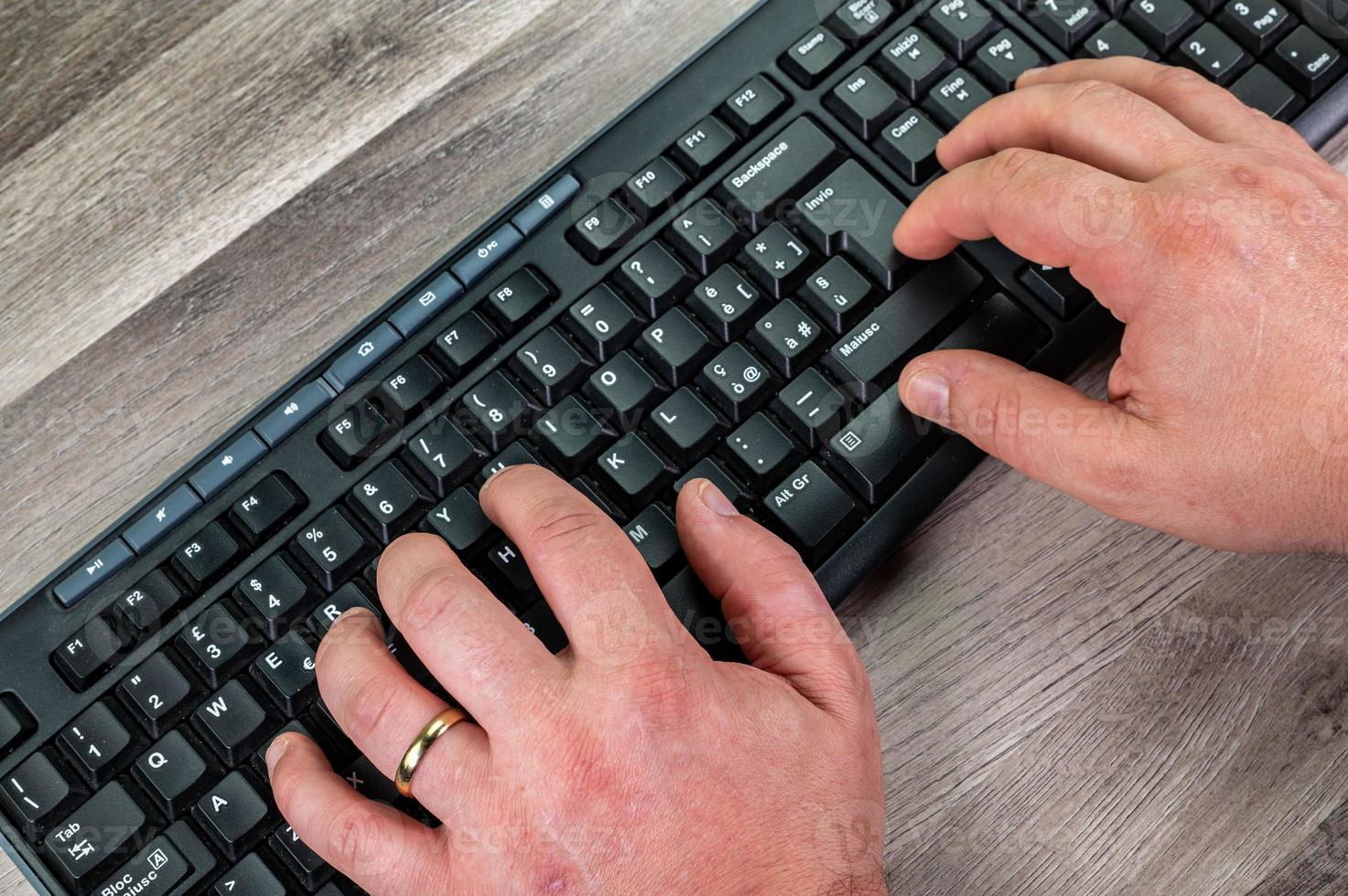 hands of a man typing on the pc keyboard photo